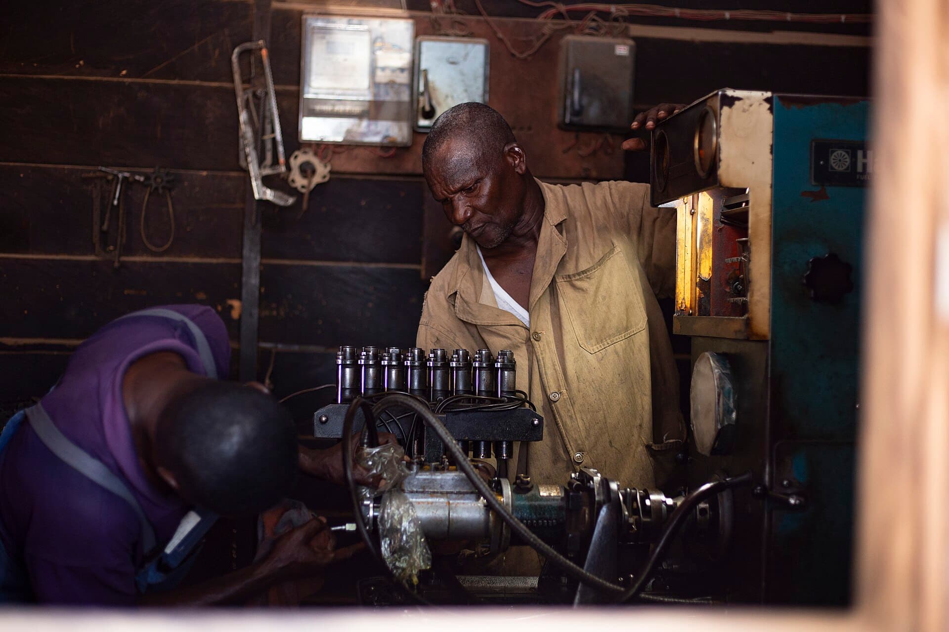African mechanics diagnosing a vehicle system in the workshop