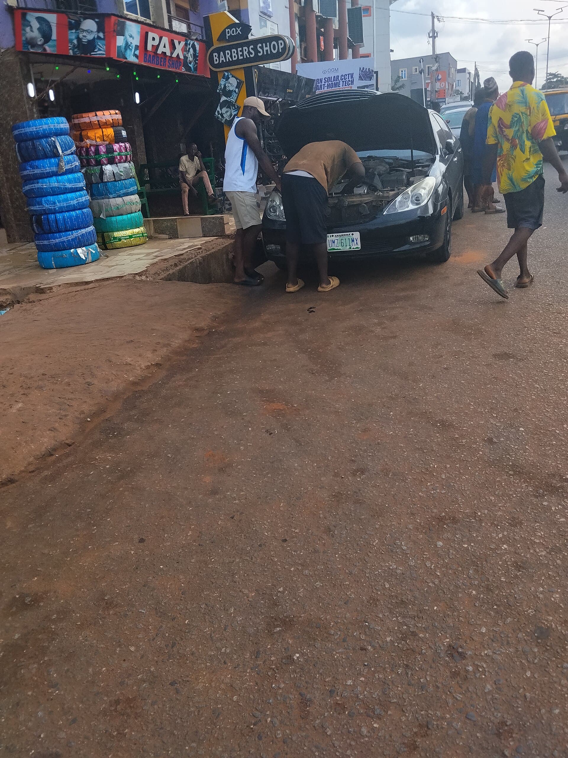 African mechanics performing mobile roadside repair on a sedan